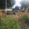 Voortuin met prairieborder en achtertuin met zwembad